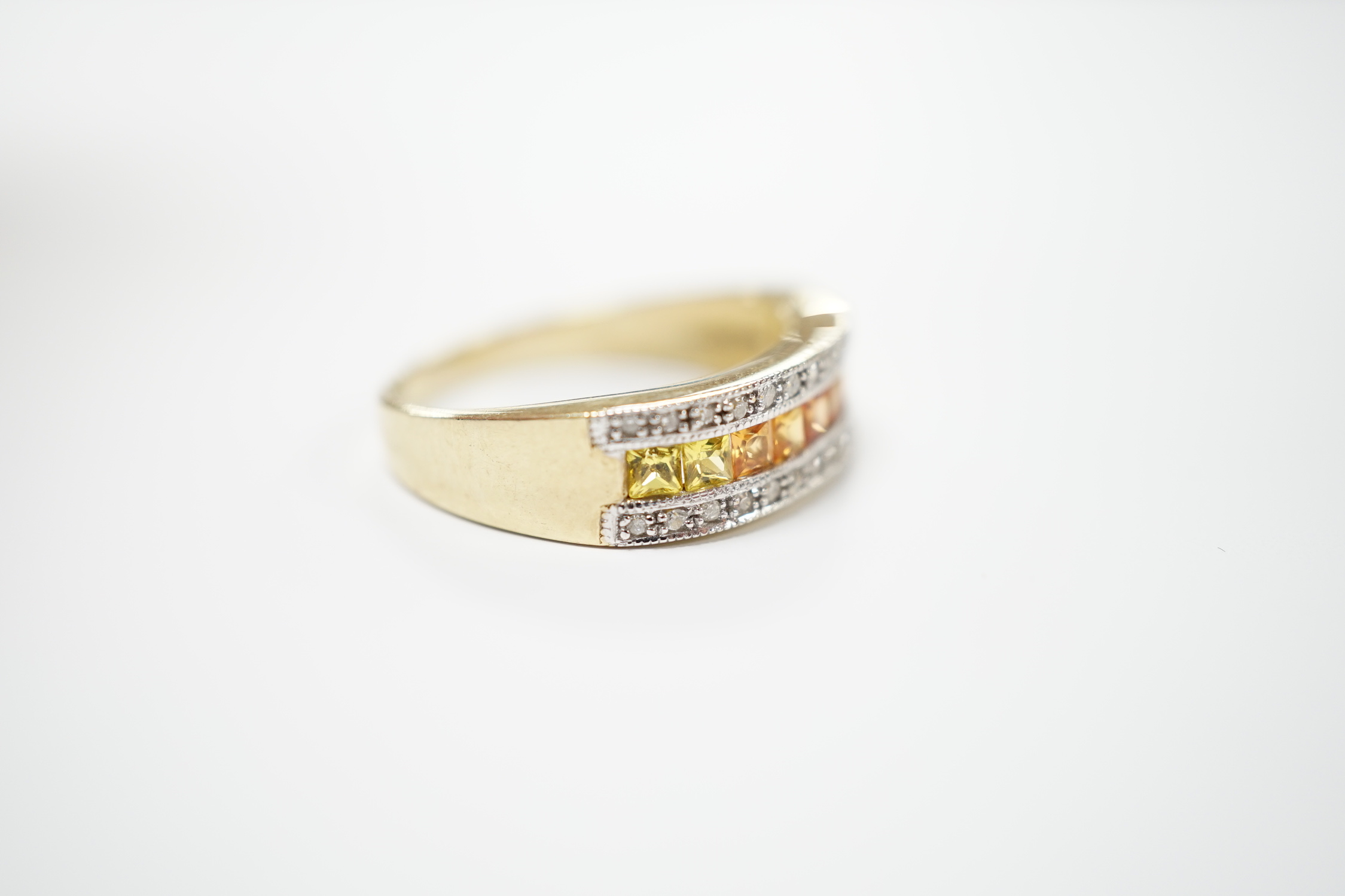 A modern 9ct gold, diamond, and two colour citrine? channel set half hoop ring, size P, gross weight 3.3 grams.